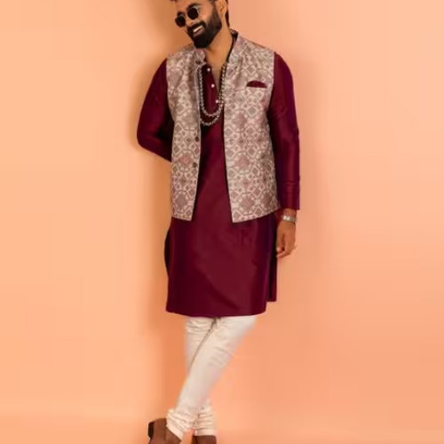 Man wearing a stylish maroon kurta with embroidered ethnic waistcoat and white pants from Olivia Clothing Store.